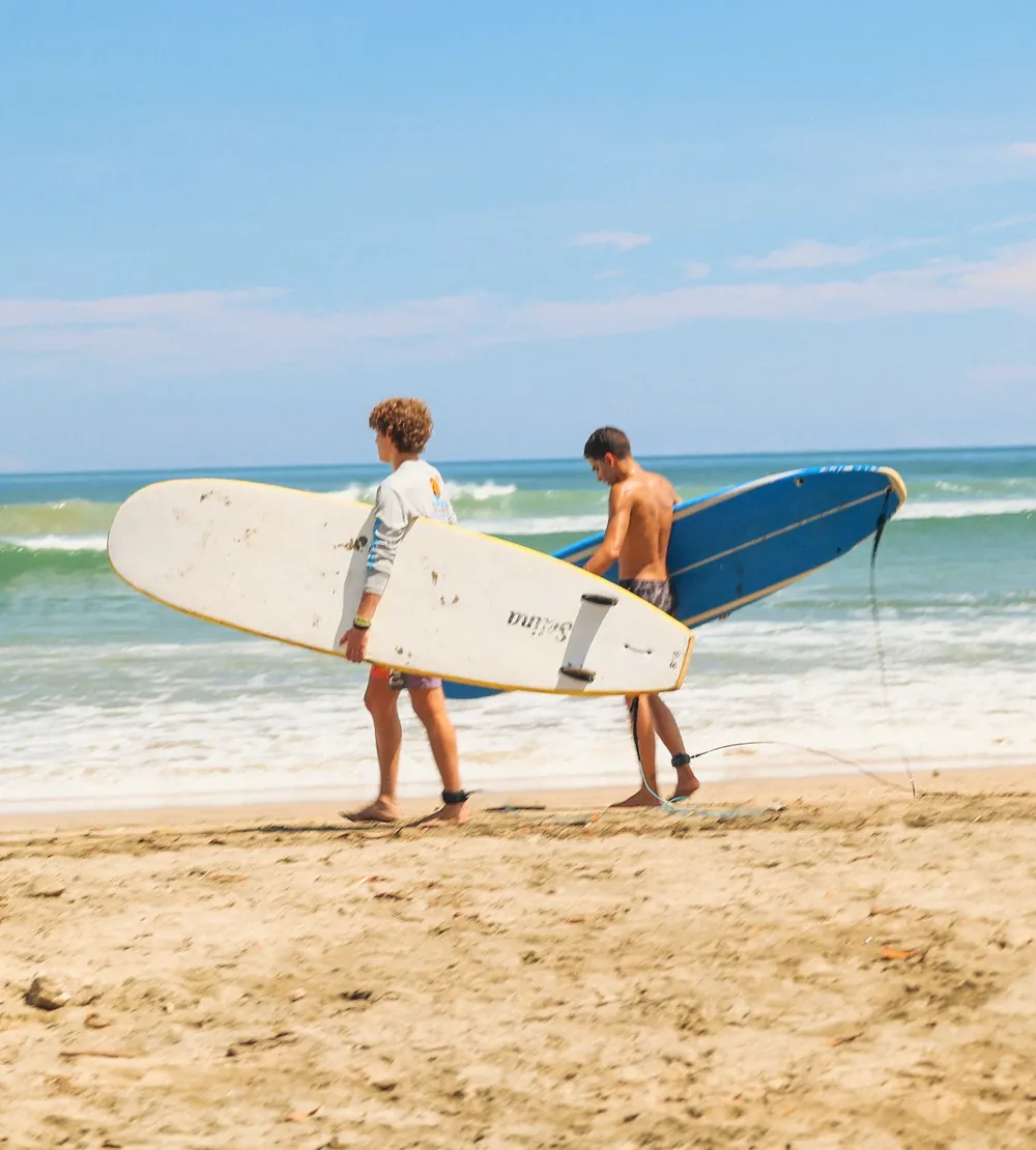 Surfistas entrando al mar con sus tablas